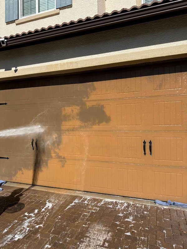 Garage door partway through oxidation treatment, with treated and untreated panels side by side